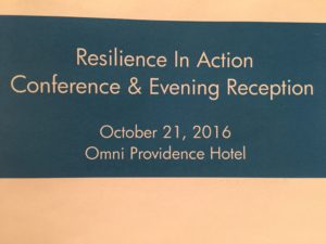 A blue sign that says resilience in action conference and evening reception.