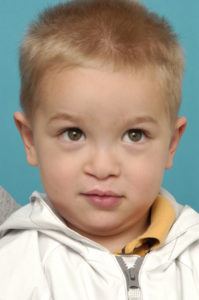 A young boy with blonde hair and blue eyes.